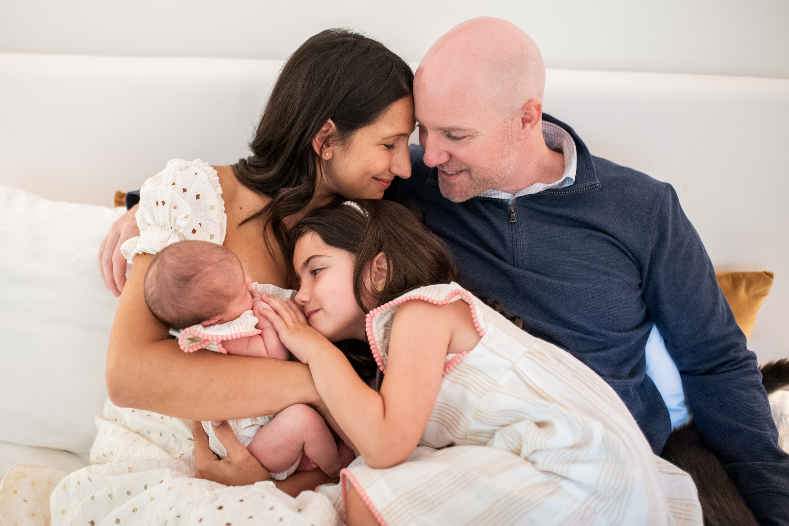 an intimate moment during an in-home newborn session with mom, dad and older sibling snuggling into each other 